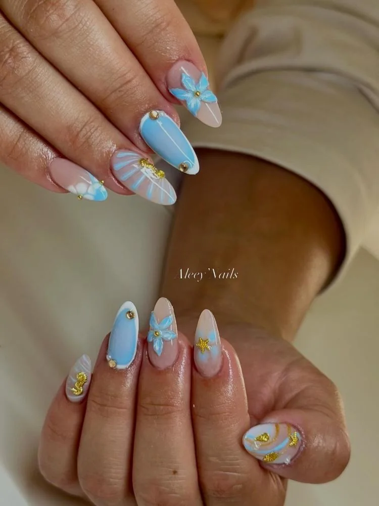Ongles amande bleu ciel avec fleur 3D et coquillages dorés